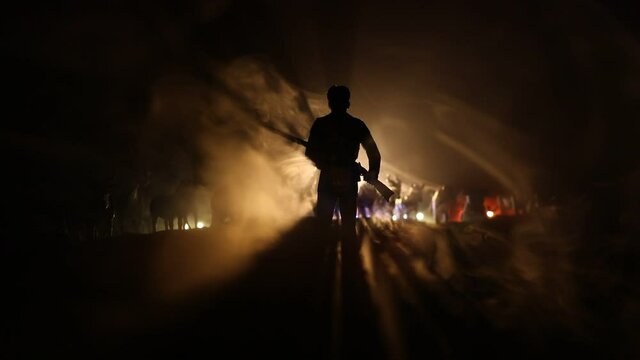 Animal protection or Hunting concept. Silhouette of a man (hunter) with rifle standing against group of animals in colorful dark backlight. Decorated with miniatures. Selective focus