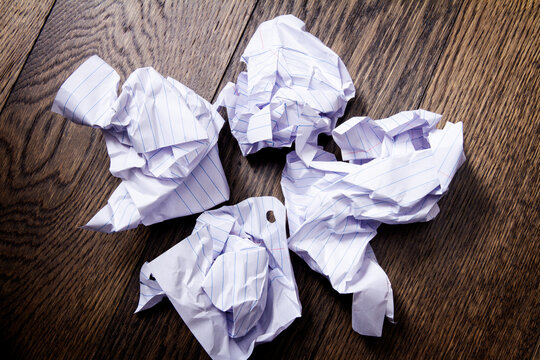 Crumpled balls of paper thrown on the floor; writer's block or start over concept