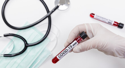 Naklejka premium Hand holding testing patients blood samples for Coronavirus Outbreak (COVID-19) in the laboratory with doctor medical equipment, New coronavirus 2019-nCoV from Wuhan China concept, with copy space