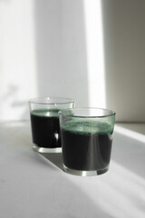 healthy breakfast drink with spirulina in glass glasses on white background