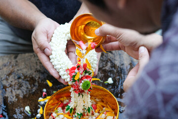 Hand of young woman pour water and flowers on the hands. older women and happy for the songkran...