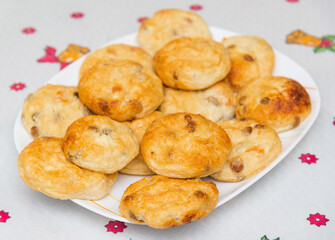 Cottage cheese pancakes close-up on a plate on a table with a white tablecloth, baked in the oven. 