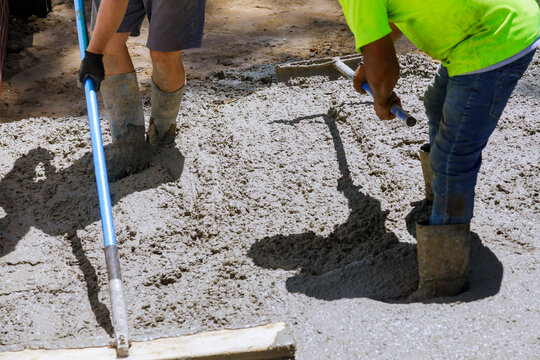 Workers concrete mixer with pouring cement during to residential on sidewalk