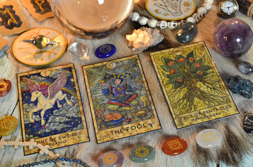 Fortune telling ritual with chakras on stones, tarot cards and runes on witch table.