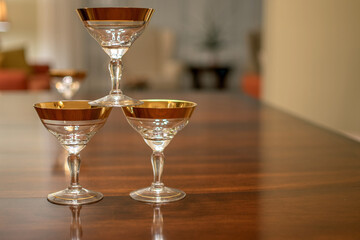 3 vintage gold rimmed champagne glasses stacked on a table