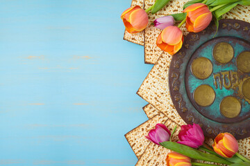 Jewish holiday Passover celebration concept with seder plate, matzah and tulip flowers on wooden table. Pesach background. - 417274191