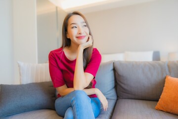 Portrait beautiful young asian woman relax smile on sofa in living area