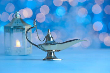 Aladdin lamp of wishes on table against blurred lights