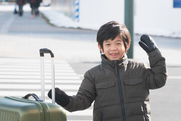 Obraz premium Cute happy Asian child with a suitcase