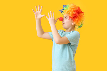 Little boy in funny disguise on color background. April Fools Day celebration