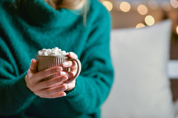 Beautiful young woman drinking hot chocolate at home, closeup