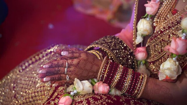 henna painted hands of a beautifully dressed Indian bride praying during wedding ceremony. Hindu arranged marriage in India, Asia