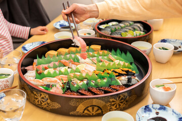 自宅で出前寿司を食べる家族