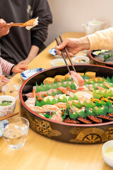 自宅で出前寿司を食べる家族