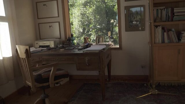 Cozy wooden studio with desk, chair and big sunny green window with a vegetation background Perfect home office Slow Motion and 60fps