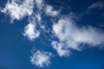 White clouds on a background of blue sky. Summer cloudy day.