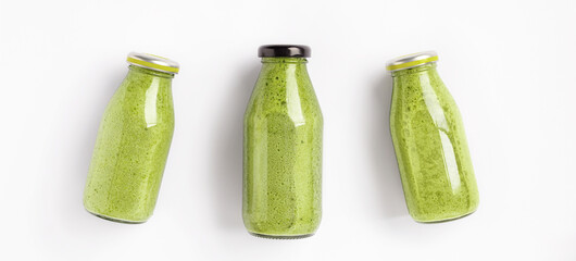 Three bottles of green smoothies on white background top view. Healthy and delicious food
