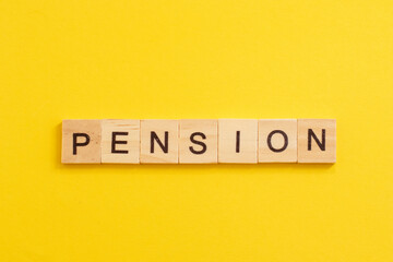Word PENSION made from wooden letters on yellow background.