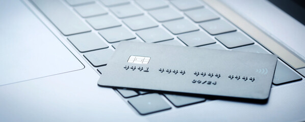 Online banking concept. Credit card on laptop keyboard close up, copy space