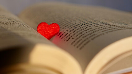 Close-up of a book with a red heart with daylight with soft focus. Love for reading literature and...