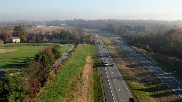 Aerial pullback above interstate highway in United States. Autumn fall foliage in New England USA.