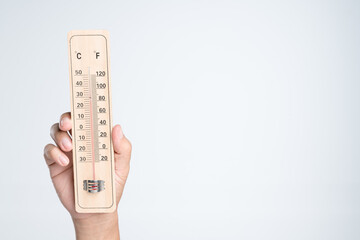 Hand holding classic thermometer for checking temperature