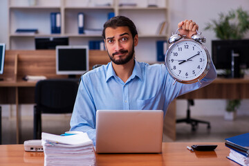 Young male employee in time management concept