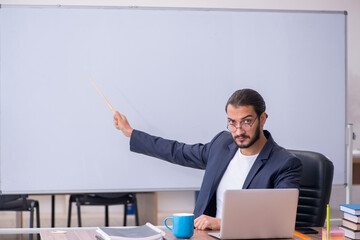 Young male teacher in the classroom