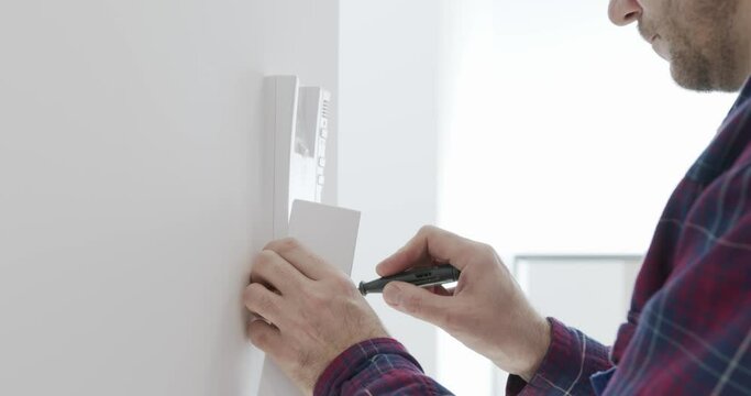 
Installation Of The Intercom. An Electrician Is Installing An Intercom At Home.