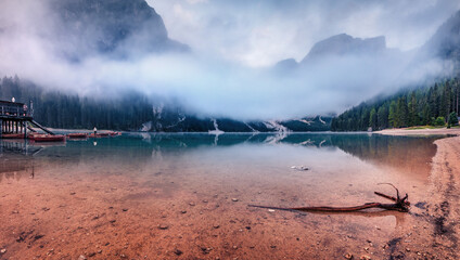 Foggy autumn view of Braies Lake. Wonderful morning scene of Dolomiti Alps, Naturpark Fanes-Sennes-Prags, Italy, Europe. Beauty of nature concept background.