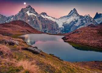 Rising moon on Bachalp lake (Bachalpsee), Switzerland. Captivating autumn suset in Swiss alps, Grindelwald, Bernese Oberland, Europe. Beauty of nature concept background.
