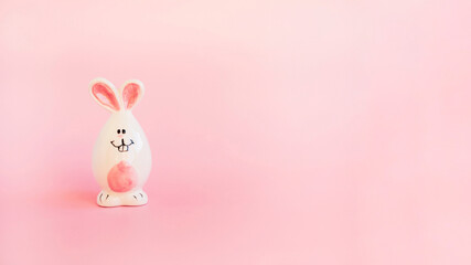 Cute white ceramic easter bunny or rabbit on pink background. Minimal Holiday concept. Symbol Happy Easter holiday. Creative. Copy space