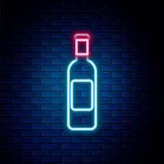 Glowing neon line Bottle of wine icon isolated on brick wall background. Colorful outline concept. Vector.