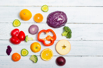 sliced fruit and vegetable circles on white wood table