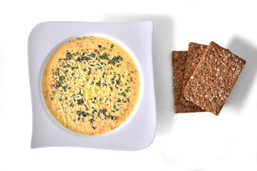 Cheese soup dish with spices isolated on white
