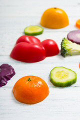 sliced fruit and vegetable circles on white wood table