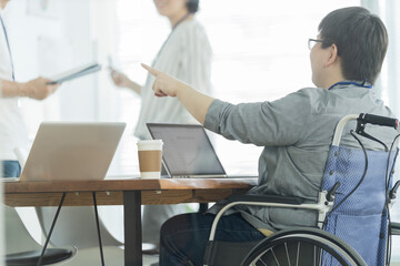 オフィスで働く車椅子の男性