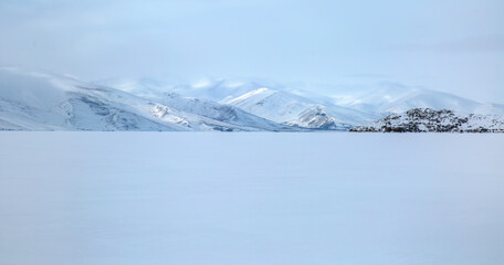 Amazing sunset over frozen Cildir Lake  in the background snowy mountains