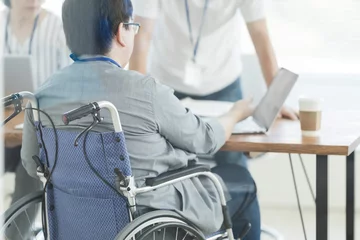 Foto op Plexiglas オフィスで働く車椅子の男性 © japolia