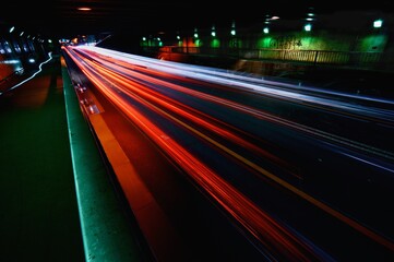 夜の道路のトンネルの中での自動車の灯火の軌跡