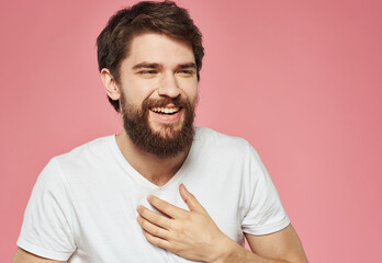 Man on a pink background in a white t-shirt emotions model cropped view