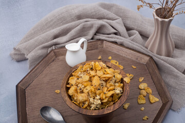 bowl of corn flakes cereals and spoon isolated on grey background.