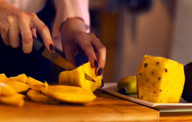 Close up of girl cutting a mango