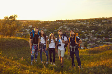 Portrait of a company of young friends of boys and girls hiking in the mountainous countryside.