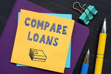  COMPARE LOANS phrase on the screen. Modern Banker use cell technologies at office.