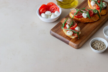 Bruschetta with ham, mozzarella, tomatoes and arugula. Wine appetizer. Snack.