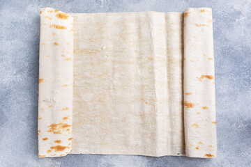 Thin Armenian lavash rolled into a roll. Texture of natural bread baking.