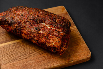 Succulent thick juicy grilled fillet steak served on an old wooden board over black background.