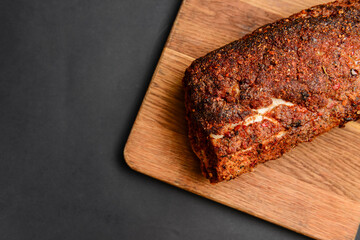 Succulent thick juicy grilled fillet steak served on an old wooden board over black background.
