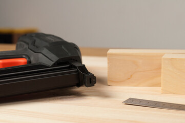 Electric stapler. On a wooden table. Wooden blocks in the workshop
